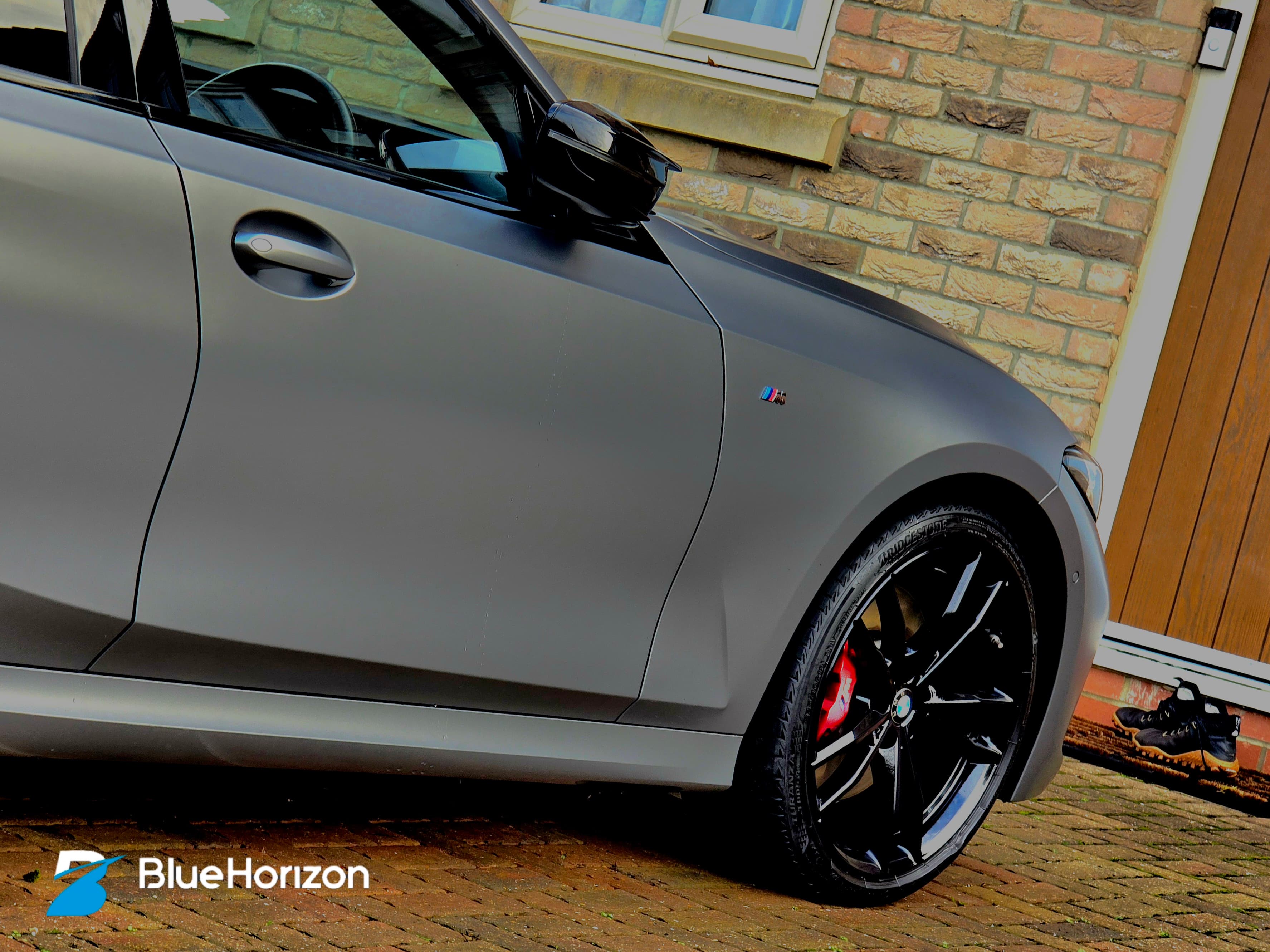 BMW M340i Touring front door showing M badge and red calipers — matte paint texture preserved with specialist products