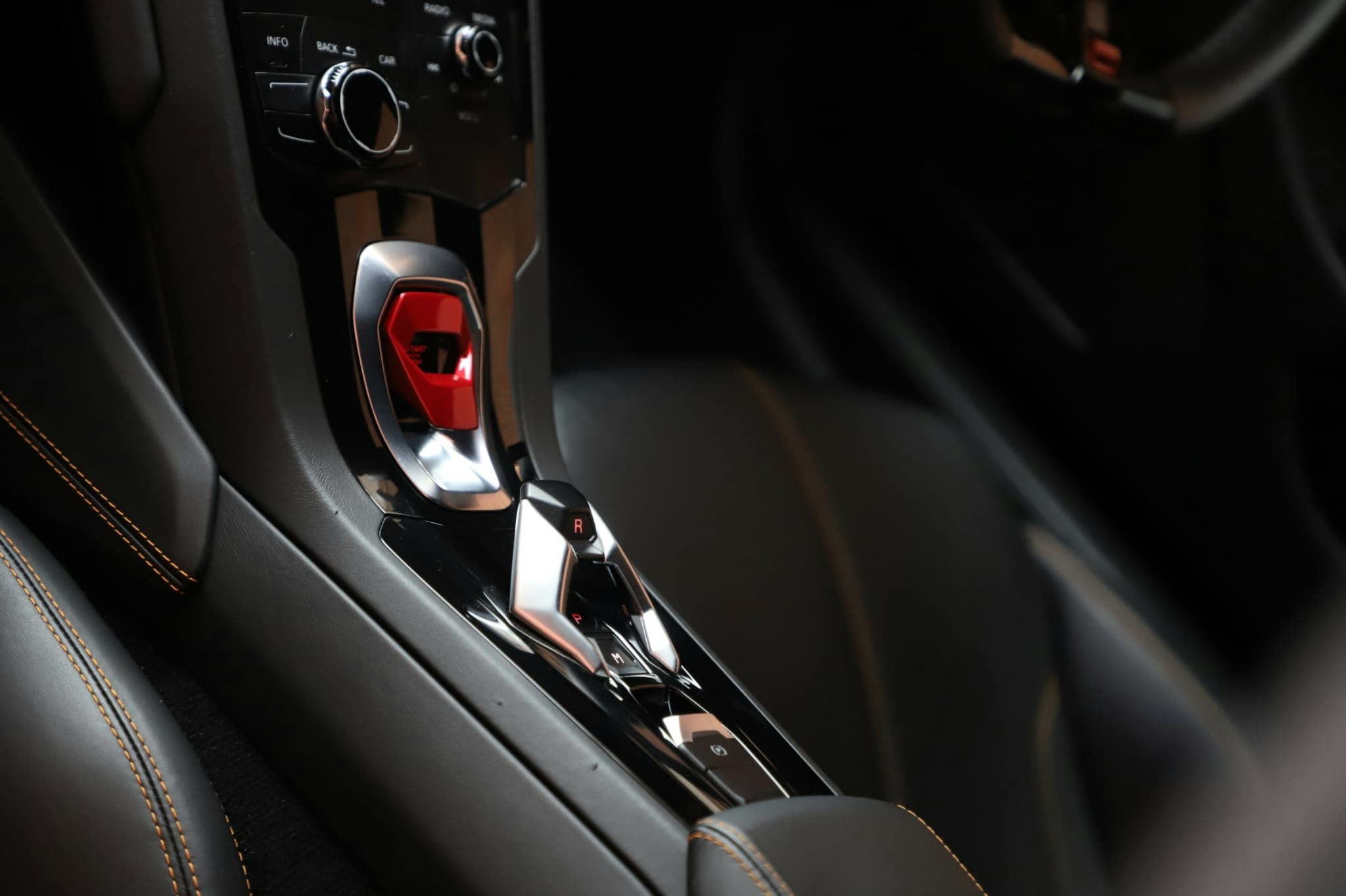 Lamborghini Huracan gear selector console with red start button and orange stitching after interior clean