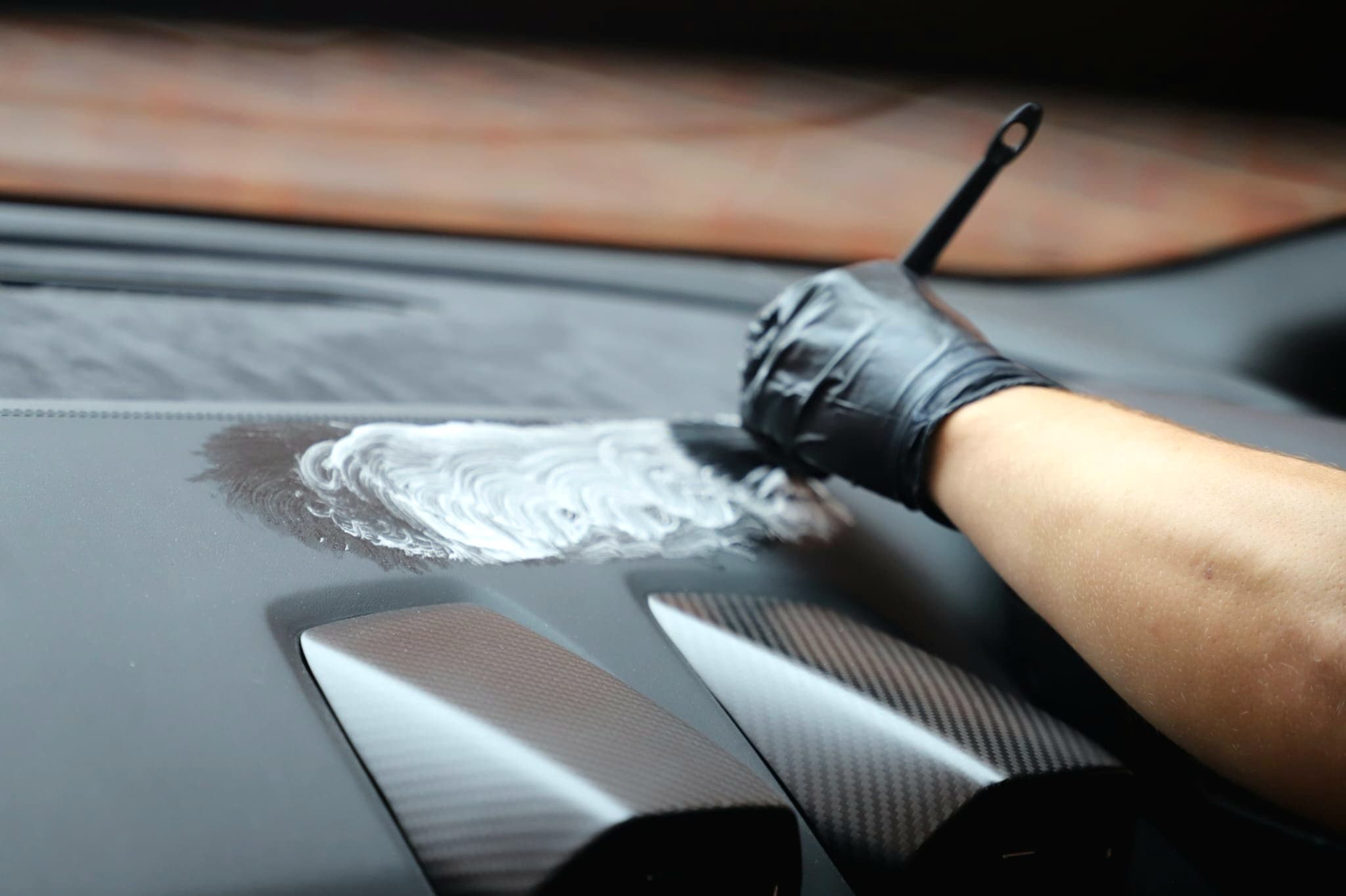 Cleaning Lamborghini carbon fibre dashboard with specialist interior product — detailing Warwickshire