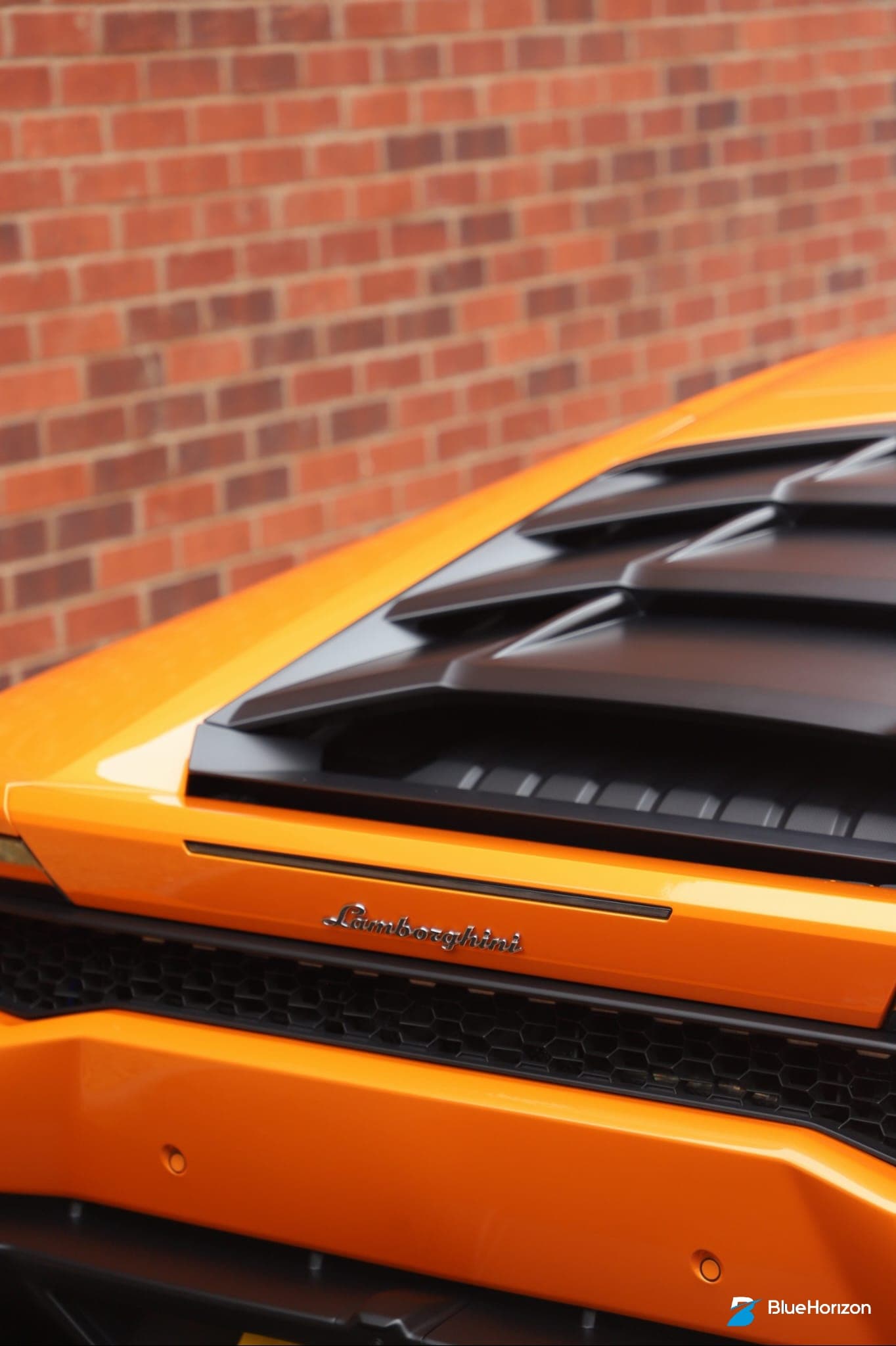 Lamborghini badge and engine vents on rear of orange Huracan after professional detail