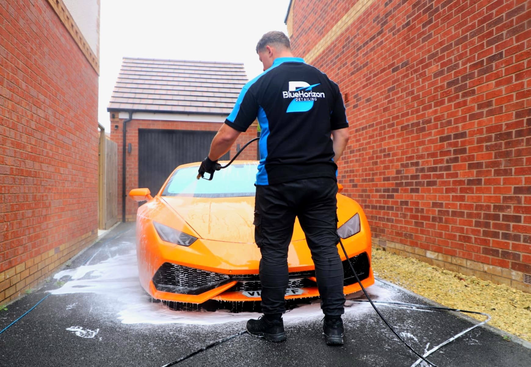 Blue Horizon Detailing — pressure washing orange Lamborghini Huracan with snow foam in Warwickshire driveway
