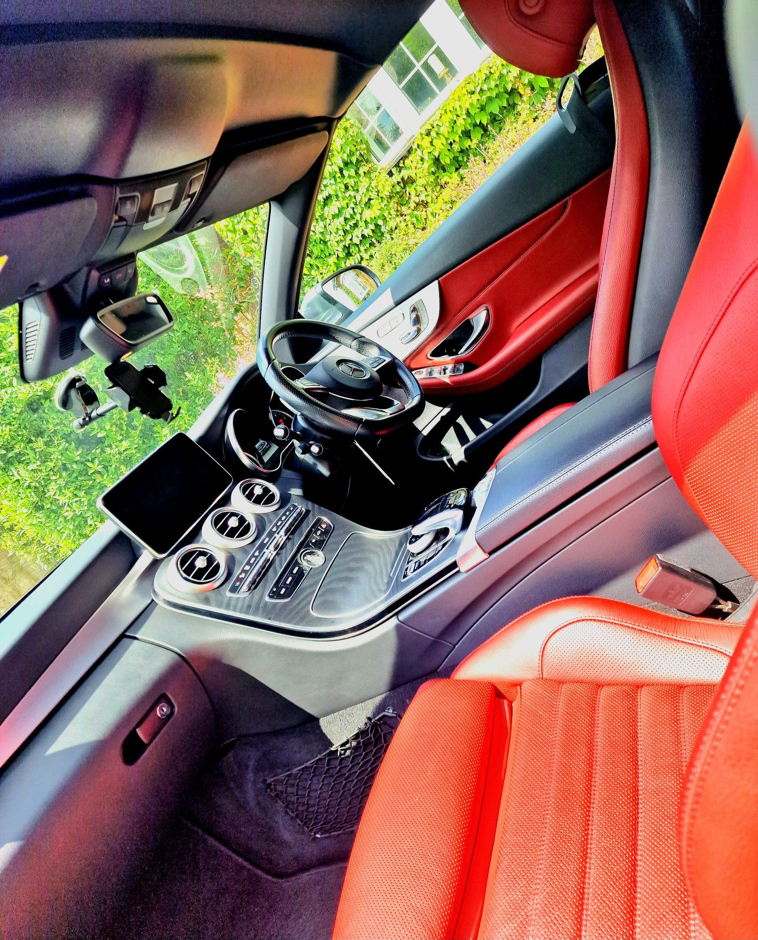 Interior of a luxury car with red leather seats and a sophisticated dashboard.