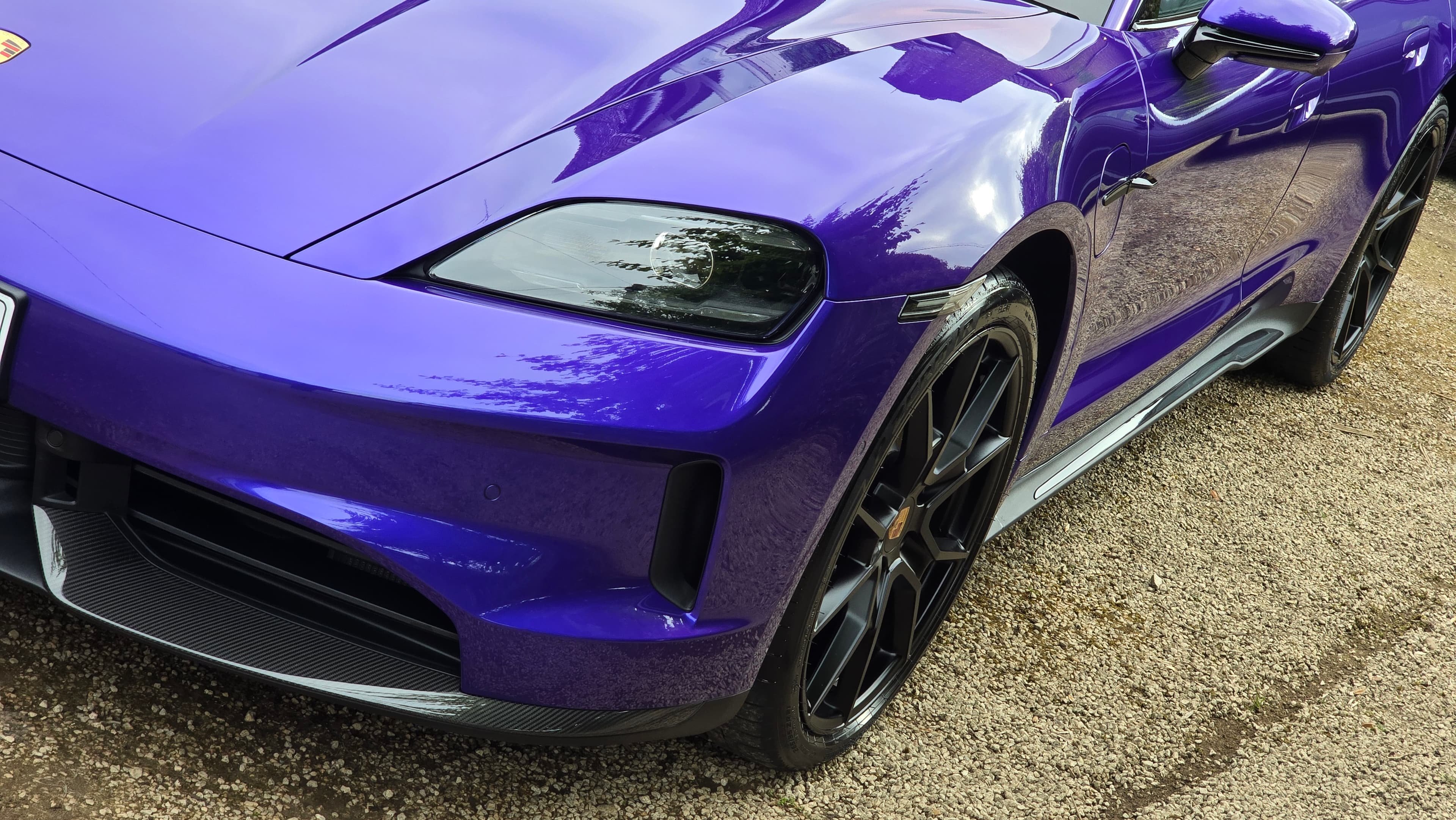 Close-up of Porsche Taycan GTS front headlight and wing after GTechniq Crystal Serum Light application