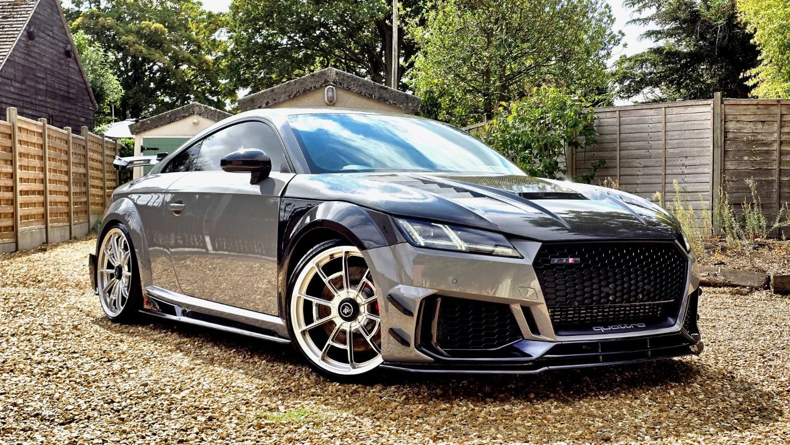 Silver Audi TT RS with carbon bodywork and gold forged wheels on a driveway
