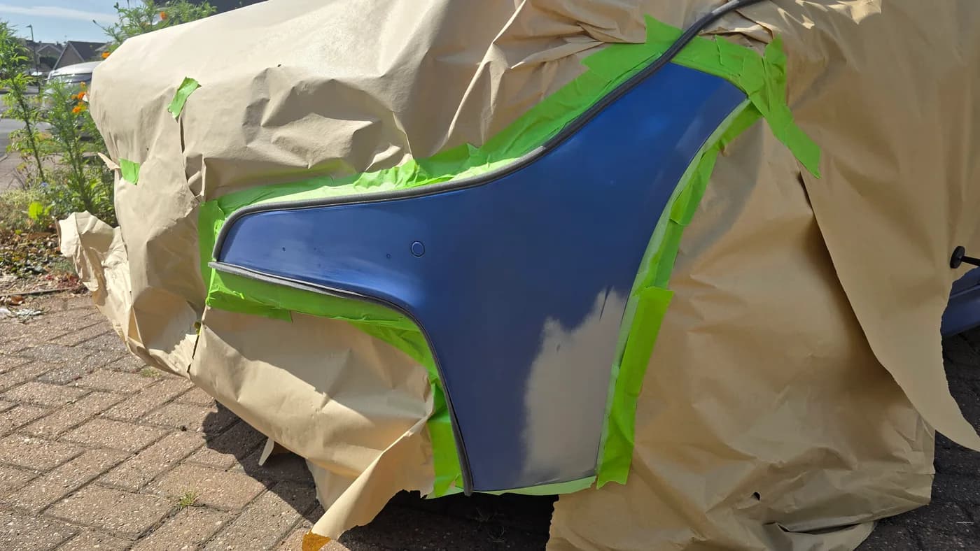 Blue BMW bumper masked and prepared for a localised paint repair
