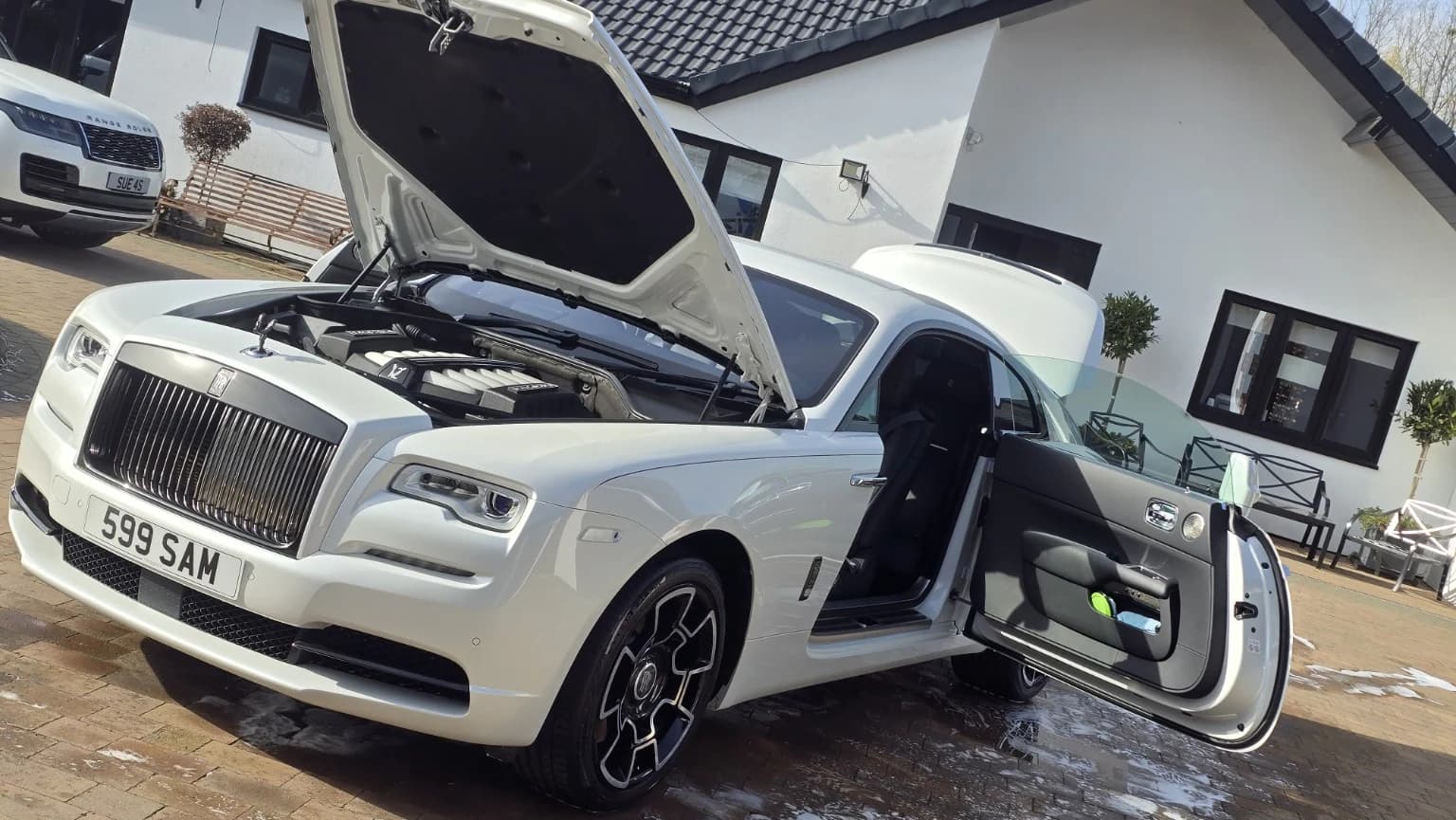 White Rolls-Royce during a comprehensive detail with its bonnet and door open