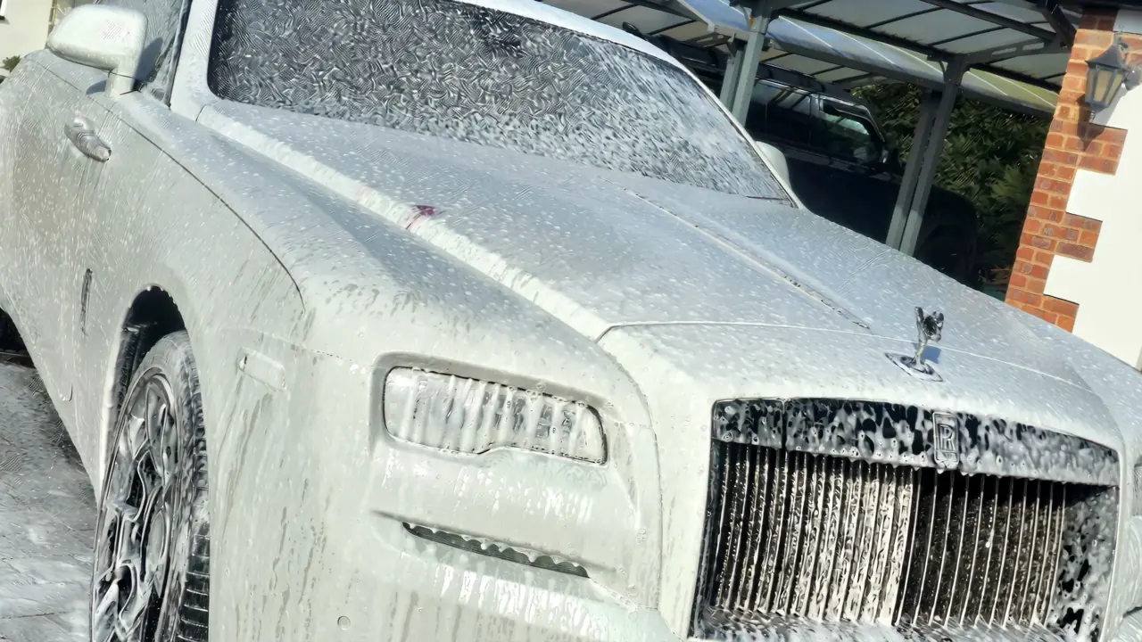 White Rolls-Royce under snow foam during a real mobile pre-wash
